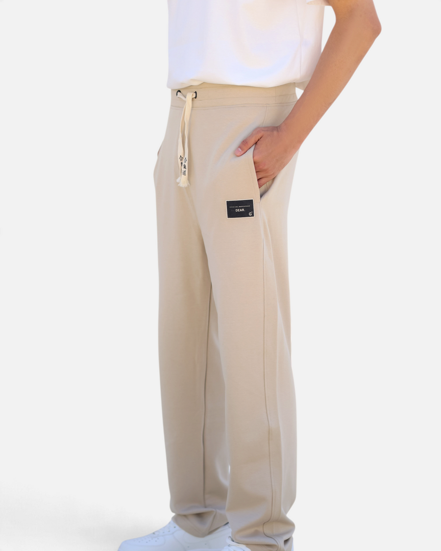 RUVR beige heavyweight fleece sweatpants with a woven label patch and Japanese-script drawstring detail