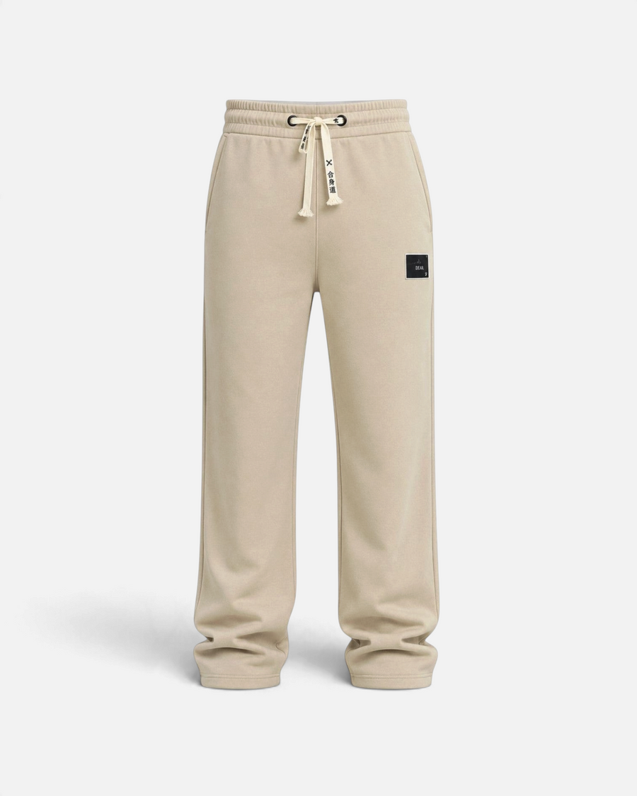 RUVR beige heavyweight fleece sweatpants with a woven label patch and Japanese-script drawstring detail.