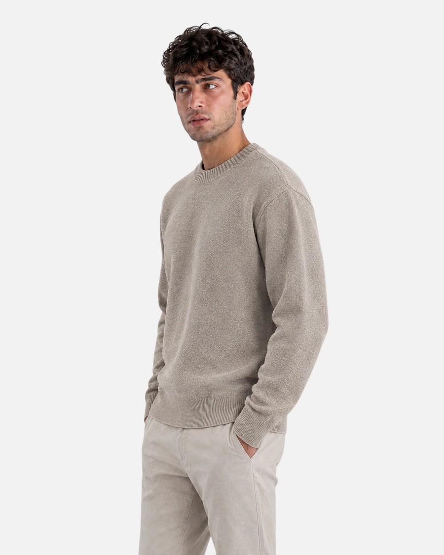 RUVR beige ribbed crew neck knit pullover worn by a man against a grey background