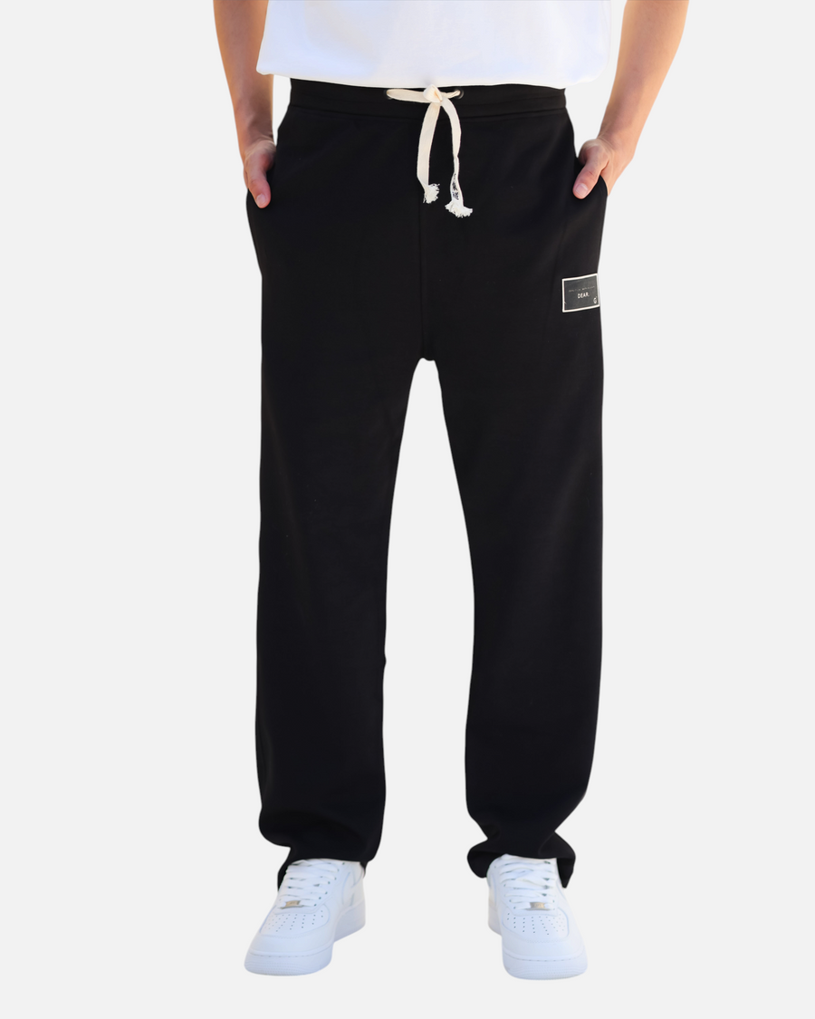 RUVR black heavyweight fleece sweatpants with a woven label patch and Japanese-script drawstring detail.