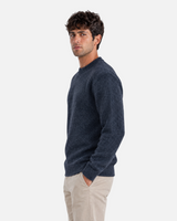 RUVR black ribbed crew neck knit pullover worn by a man with hands in pockets against a grey background