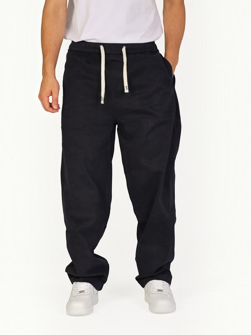 RUVR black Urban Utility Pants with an elastic drawstring waistband worn by a man in a relaxed modern fit