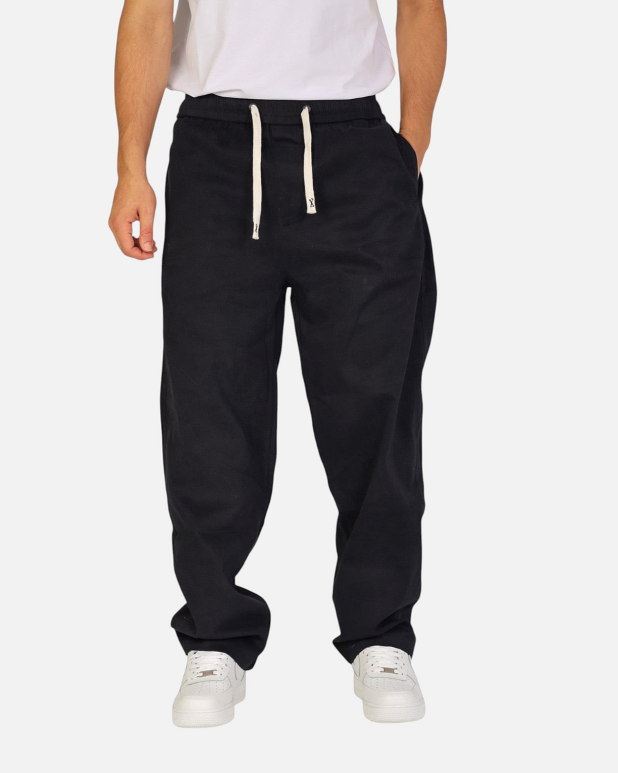RUVR black Urban Utility Pants with an elastic drawstring waistband worn by a man in a relaxed modern fit