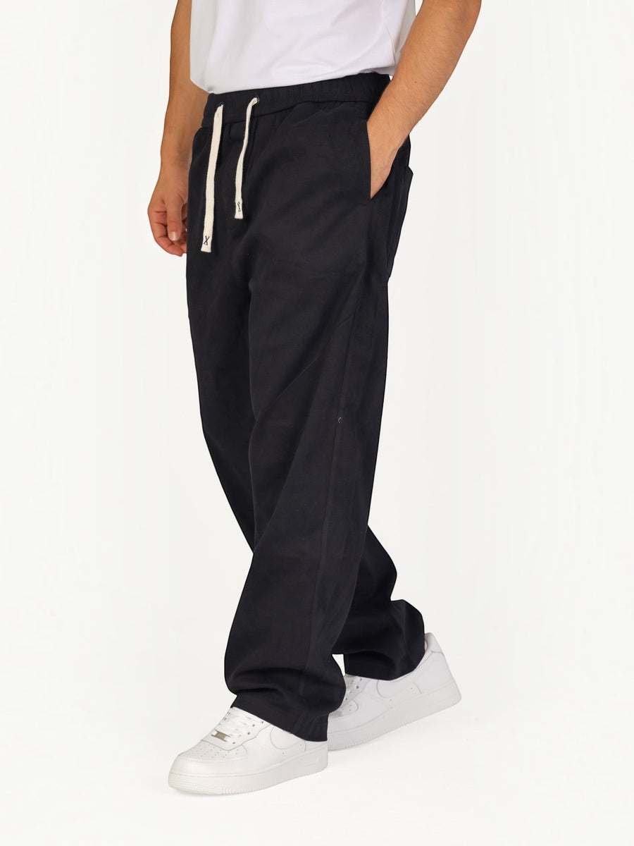 RUVR Urban Utility Pants in black with a relaxed fit, elastic drawstring waistband, and side pockets on a model.