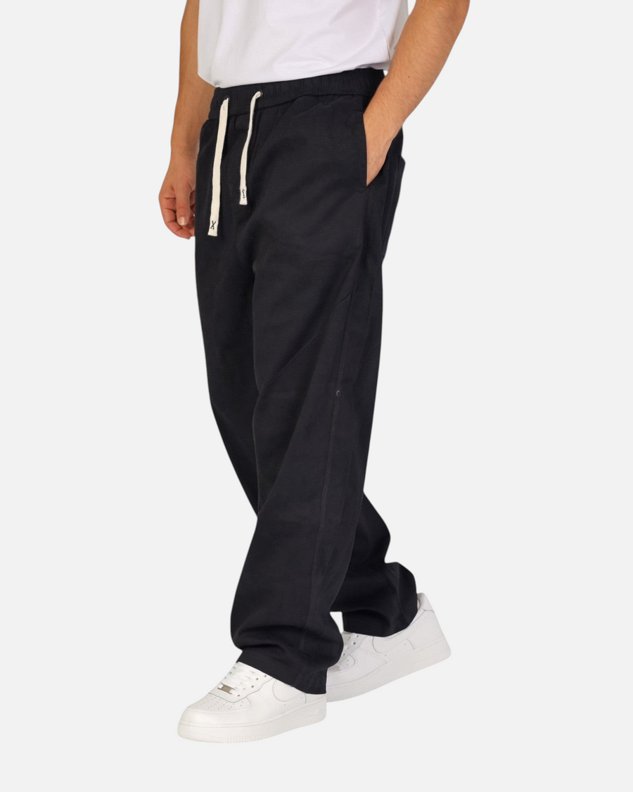 RUVR Urban Utility Pants in black with a relaxed fit, elastic drawstring waistband, and side pockets on a model.