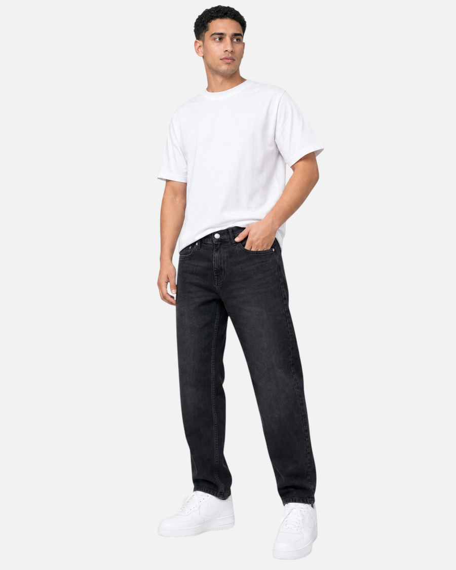 RUVR Ease Relaxed Fit Denim in black worn by a male model with a white t-shirt and white sneakers