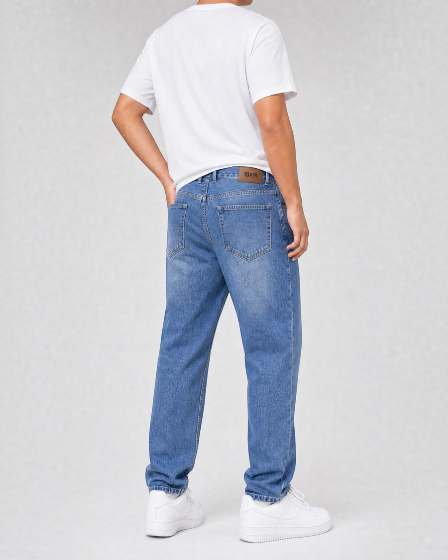 RUVR Ease Relaxed Fit blue denim jeans with a tapered leg and 5-pocket construction, viewed from the back.