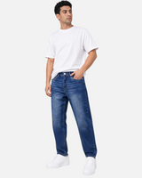 RUVR Ease relaxed fit blue denim jeans with a tapered leg and five-pocket design worn by a male model