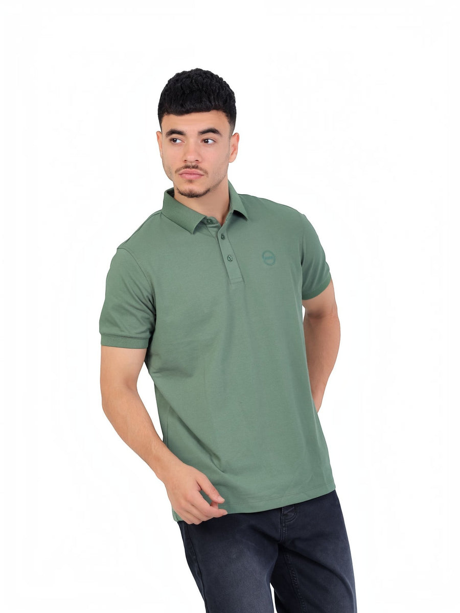 RUVR Essential Polo in sage green cotton piqué with a tonal embossed chest emblem and classic three-button placket