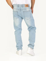 Back view of RUVR Haze Denim straight-leg jeans in light stonewash cotton with a tan leather brand patch.