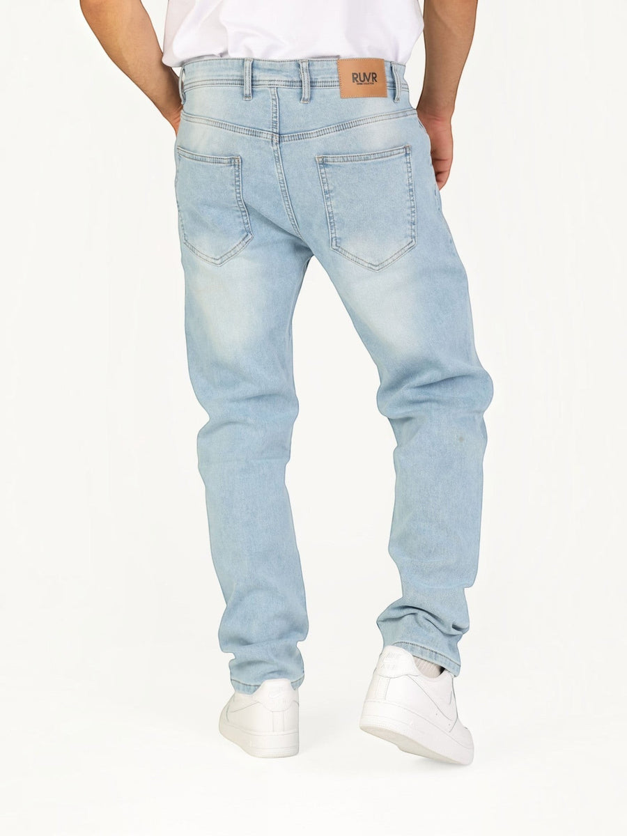 Back view of RUVR Haze Denim straight-leg jeans in light stonewash cotton with a tan leather brand patch.