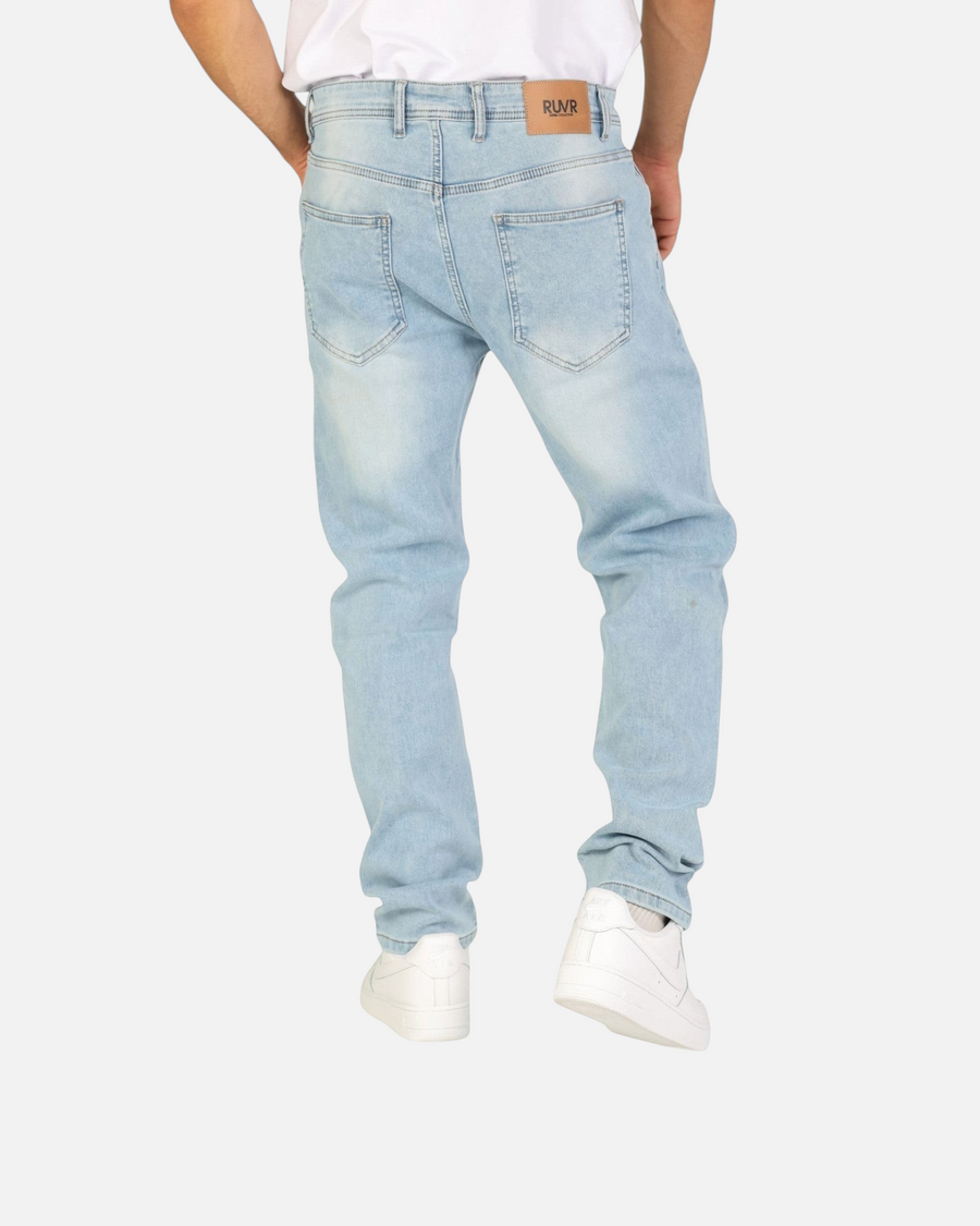 Back view of RUVR Haze Denim straight-leg jeans in light stonewash cotton with a tan leather brand patch.