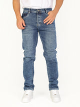 Model wearing RUVR Haze Denim straight-leg jeans in a stonewash blue finish with five-pocket construction.