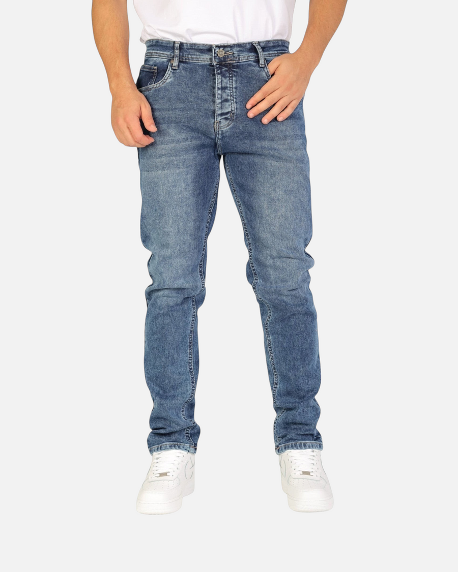 Model wearing RUVR Haze Denim straight-leg jeans in a stonewash blue finish with five-pocket construction.