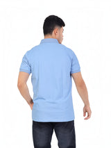 Back view of a man wearing a light blue RUVR Essential Polo shirt in cotton piqué with ribbed collar and cuffs.