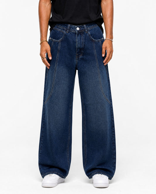 RUVR wide leg denim jeans in navy blue with curved seam construction on a model against a white background