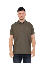 A model wearing a RUVR olive green cotton piqué polo shirt with a classic collar and tonal embossed chest emblem.