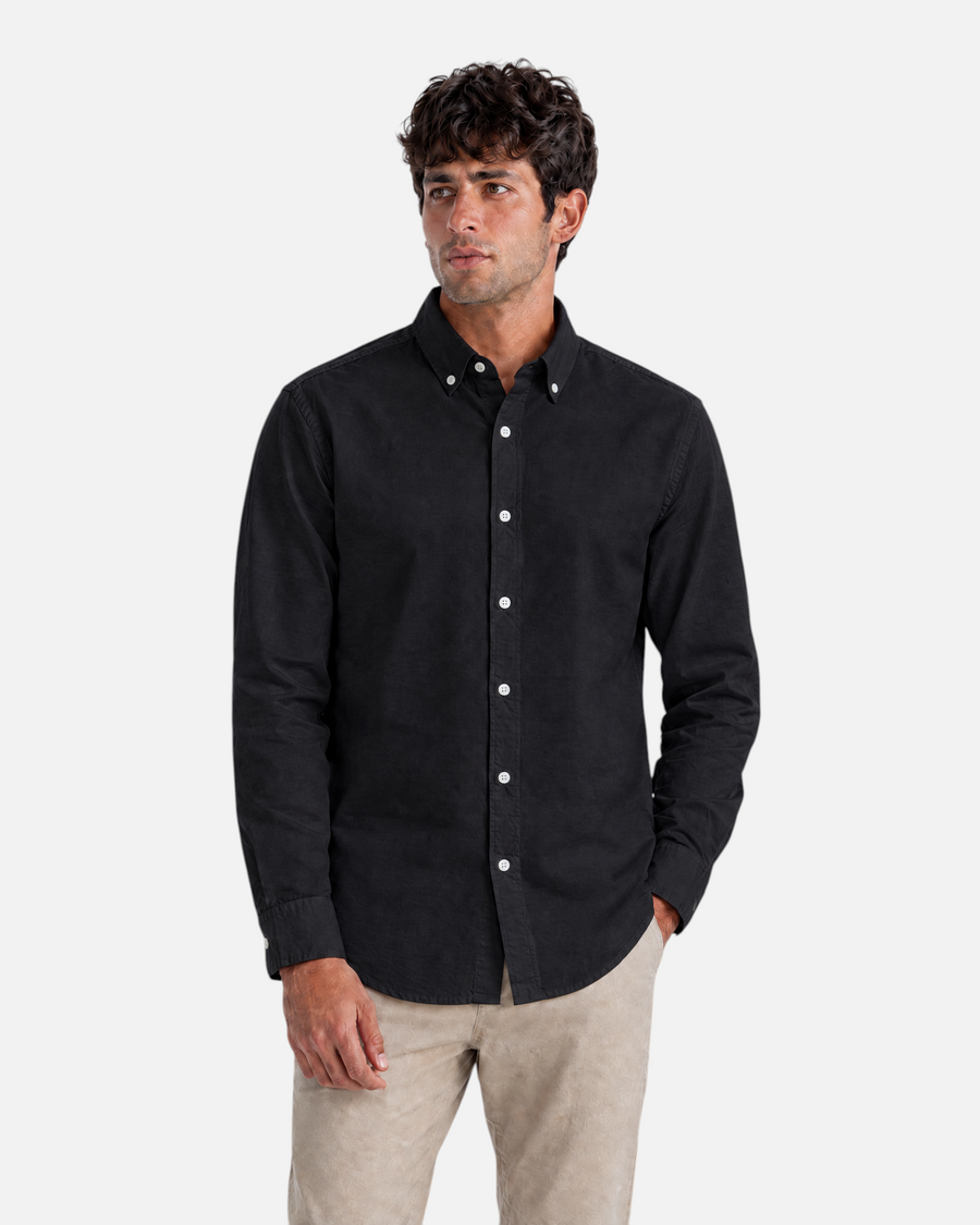 RUVR Press Shirt in black with a button-down collar, worn by a man with beige trousers.