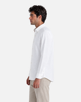 A man wearing a RUVR white long-sleeve button-down Press Shirt with a tailored fit, viewed from the side.