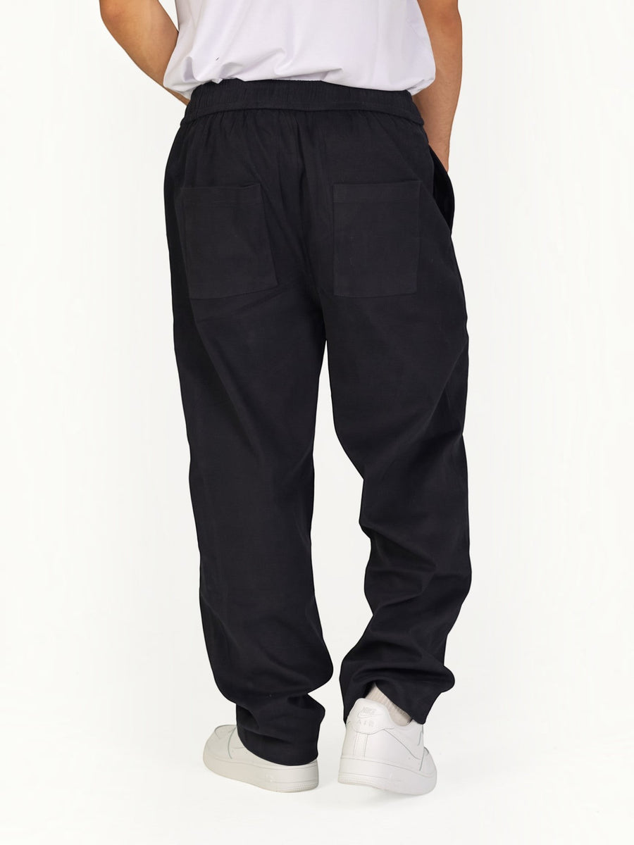 RUVR Urban Utility Pants in black with a relaxed fit, elastic waistband, and back pockets, worn by a model.
