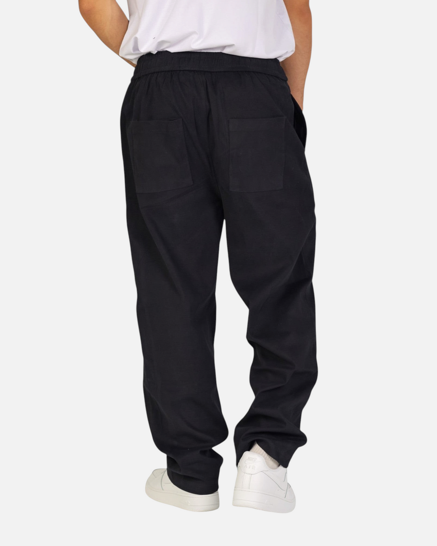 RUVR Urban Utility Pants in black with a relaxed fit, elastic waistband, and back pockets, worn by a model.