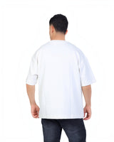 Back view of a man wearing a RUVR white oversized heavyweight cotton tee with a relaxed dropped-shoulder fit.