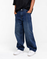 RUVR wide leg denim jeans in dark blue wash featuring curved seam construction and a relaxed fit on a male model.