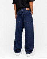 RUVR wide leg navy denim jeans worn by a man, featuring a relaxed fit and back leather brand patch